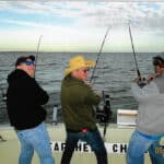Three guys catching fishing on Searcher Charters